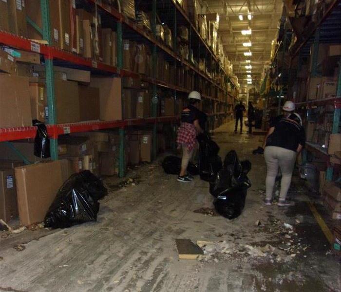 SERVPRO crew in action cleaning in warehouse.