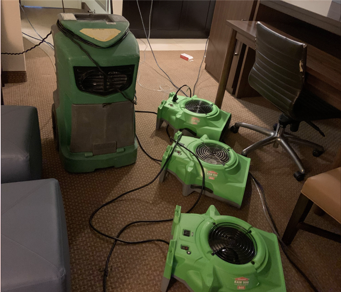 Air movers and dehumidifier on floor.